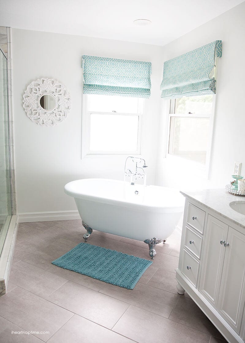 Bathroom makeover via I Heart Naptime: Grey and white bathroom remodel with Carrara marble herringbone tile tile, white vintage tub and blue accents. 