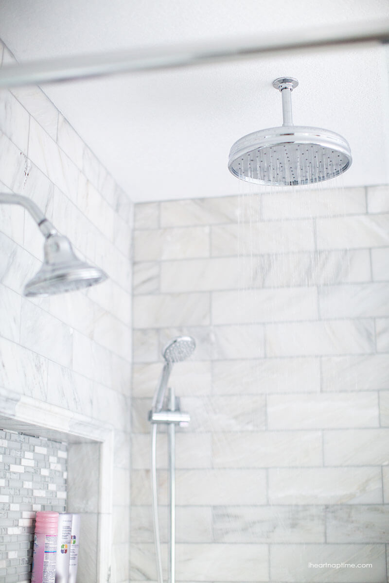 Bathroom makeover via I Heart Naptime: Grey and white bathroom remodel with Carrara marble herringbone tile tile, white vintage tub and blue accents. 