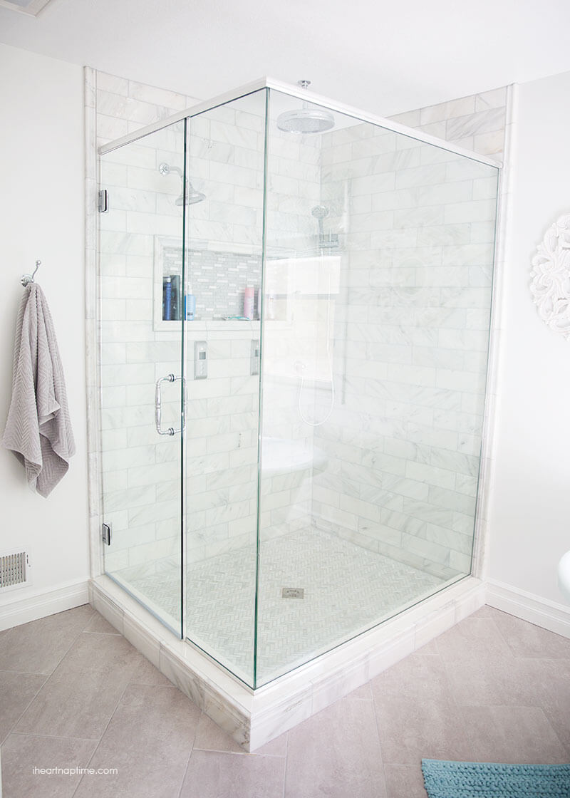 Bathroom makeover via I Heart Naptime: Grey and white bathroom remodel with Carrara marble herringbone tile tile, white vintage tub and blue accents. 