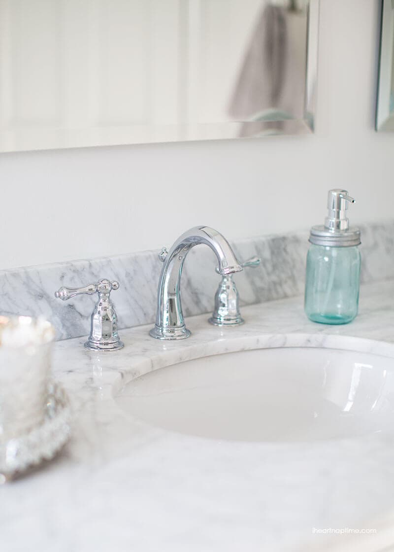 Bathroom makeover via I Heart Naptime: Grey and white bathroom remodel with Carrara marble herringbone tile tile, white vintage tub and blue accents. 