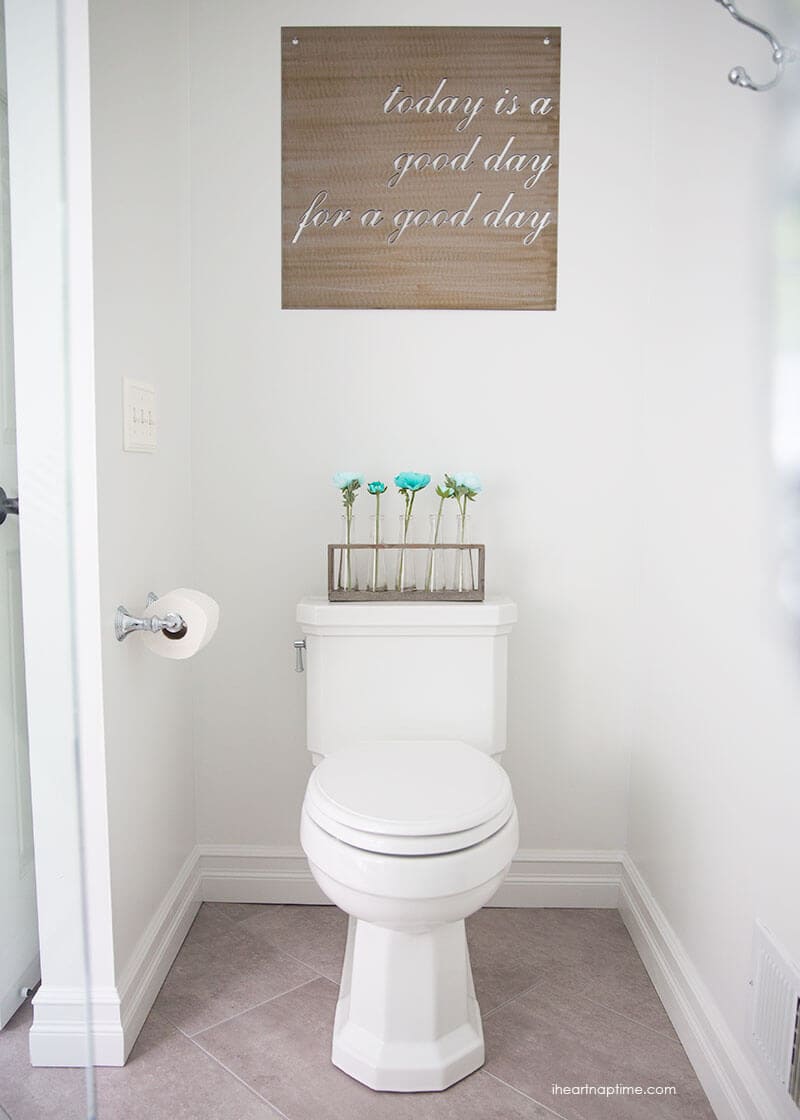 Bathroom makeover via I Heart Naptime: Grey and white bathroom remodel with Carrara marble herringbone tile tile, white vintage tub and blue accents. 