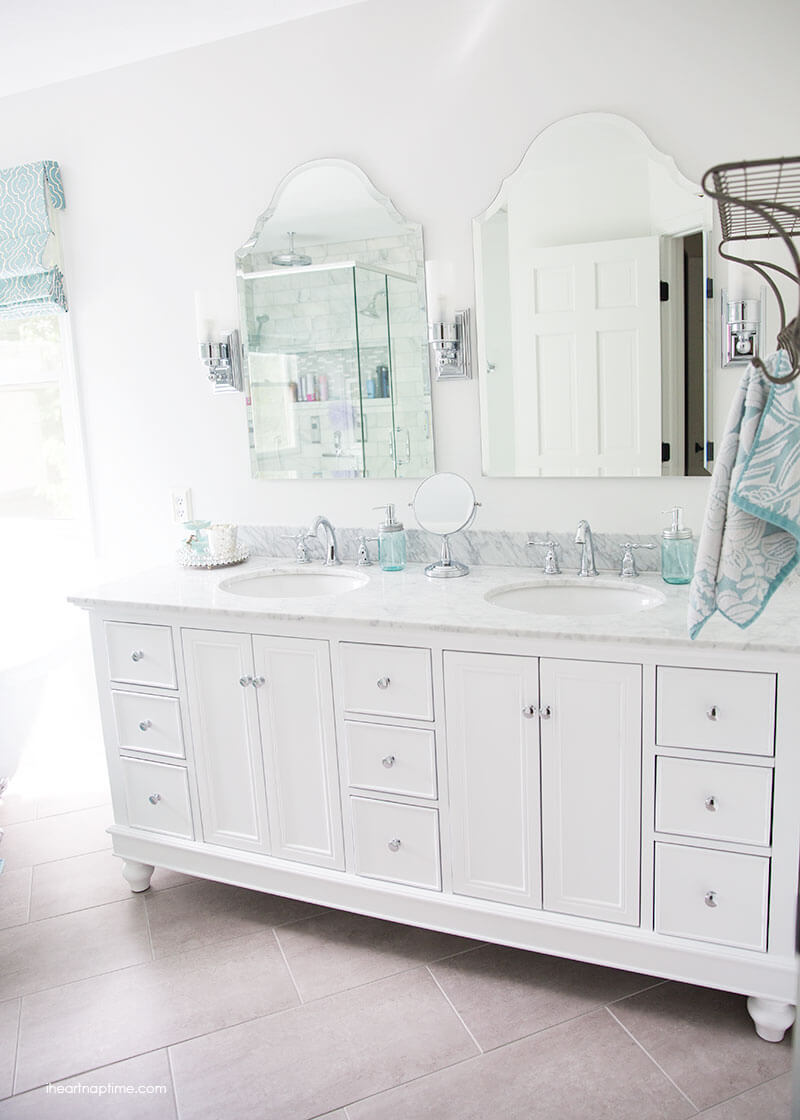 Bathroom makeover via I Heart Naptime: Grey and white bathroom remodel with Carrara marble herringbone tile tile, white vintage tub and blue accents. 