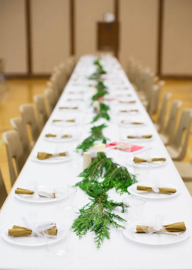 Light the World Designs... during this Christmas season, we participated in this wonderful initiative and it has been so valuable to focus on the true meaning of Christmas. For the long tables we wrapped them in white butcher paper. Then we ran fresh Christmas pine down the center of the tables. We did white plastic plates and then wrapped the utensils with gold napkins and tied them with white tulle. Super easy, inexpsensive and adds a nice touch!