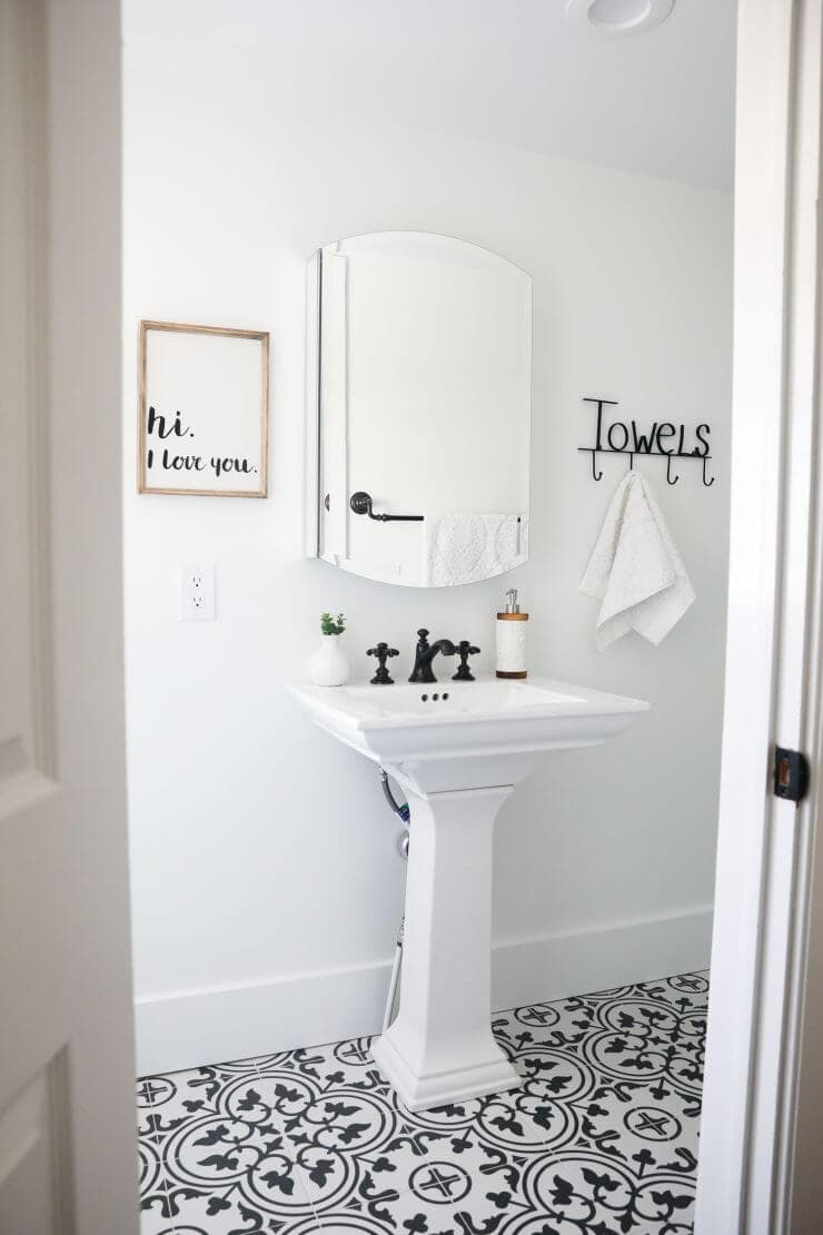 Black and white bathroom makeover on a 1888 fixer upper: white subway tile, oil rubbed bronze finishes + cement tile 