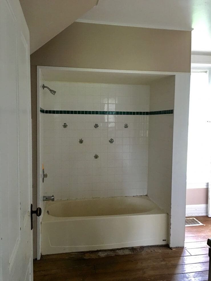 Fixer upper style bathroom makeover with clawfoot tub, watery paint color and sliding barn door.