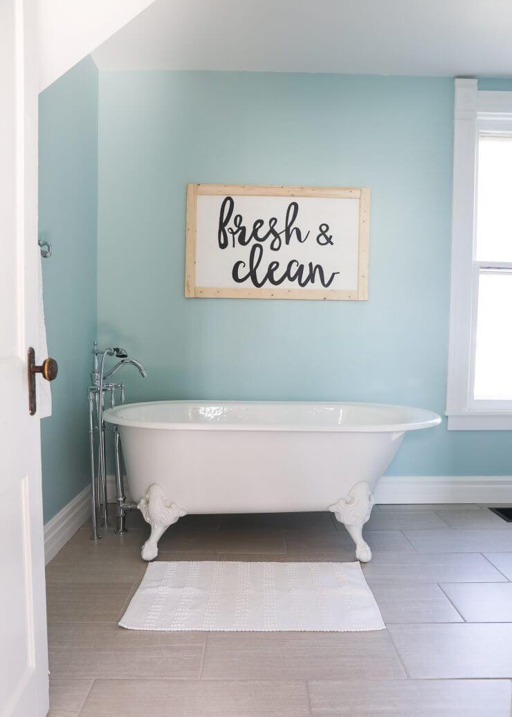 Fixer Upper Bathroom Before and Afters... fixer upper style bathroom makeover with clawfoot tub, watery paint color and sliding barn door.