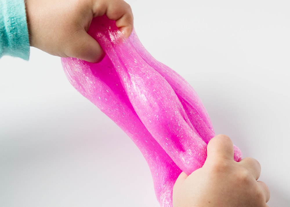 pulling glitter slime with hands 
