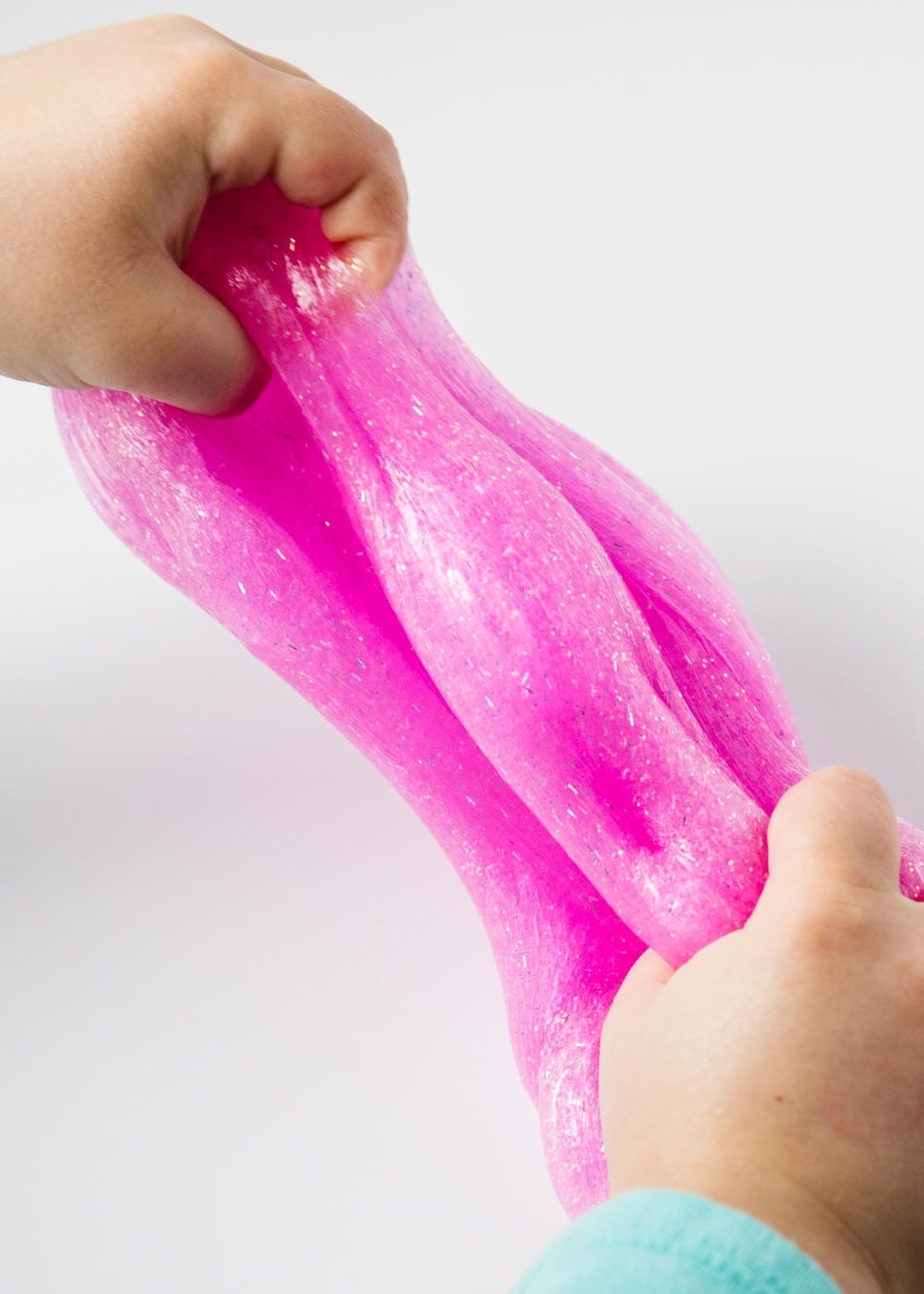 pulling glitter glue slime with hands 