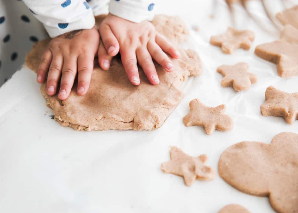 The perfect holiday craft for your little ones! Leave your house smelling like Christmas with this fun and inexpensive gingerbread playdough. playing with gingerbread playdough
