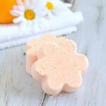 flower-shaped orange bath bombs on a wood surface