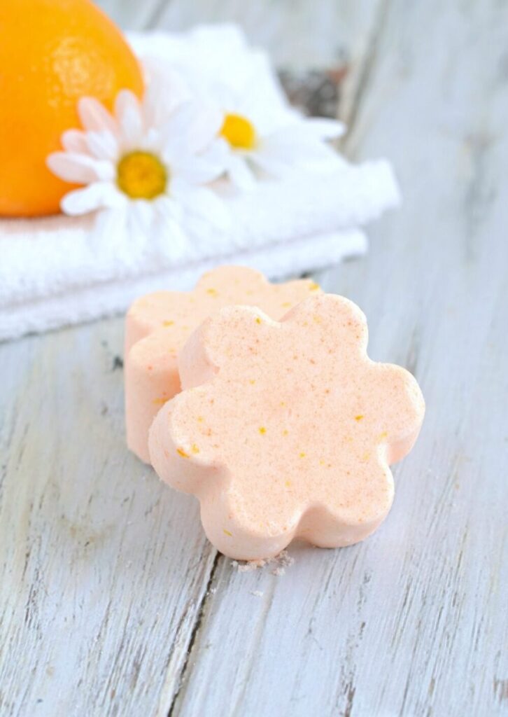 flower-shaped orange bath bombs on a wood surface 