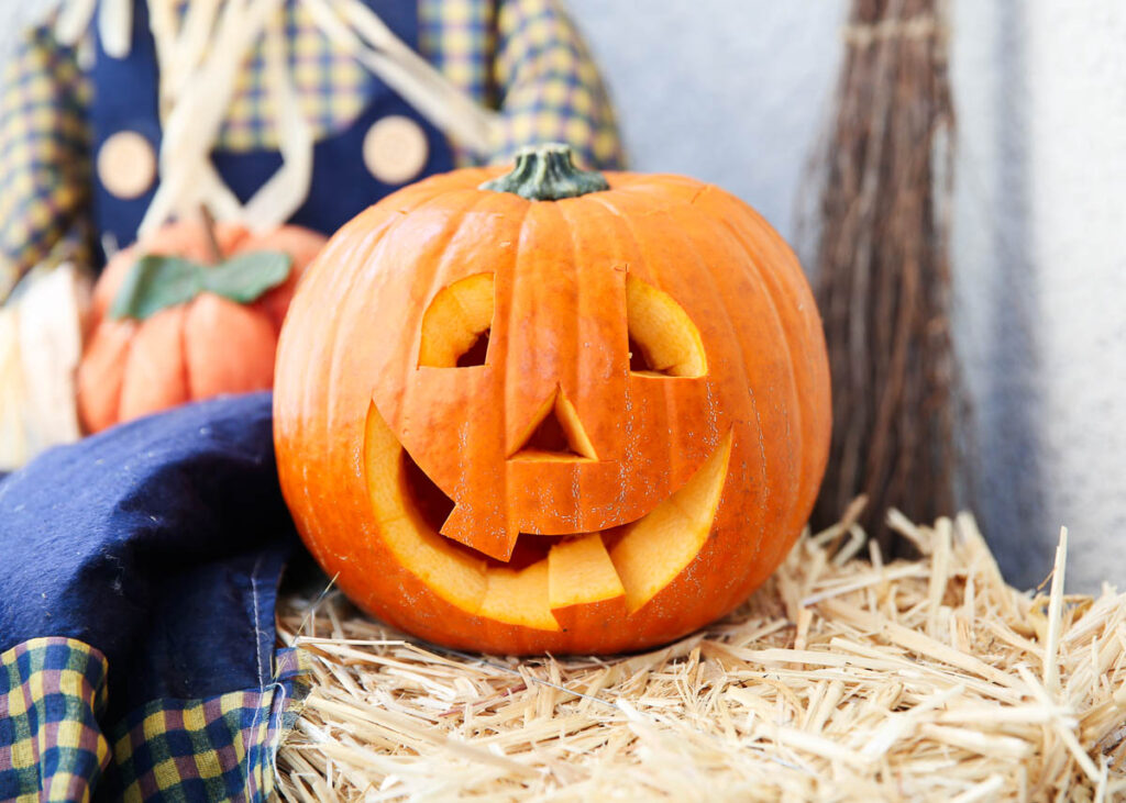 carved pumpkin on hay stack