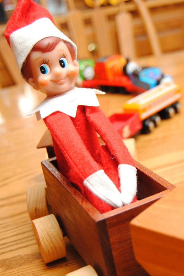 Elf sitting on a toy train. 
