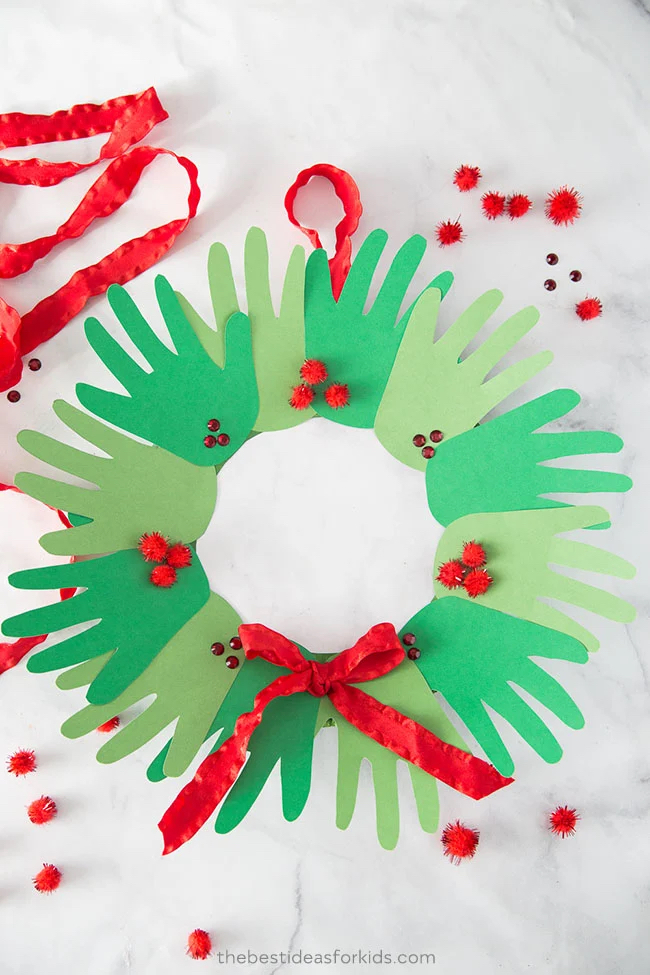 Easy Christmas Crafts for Kids...festive ideas to help bring the holiday cheer into your home this season. Simple instructions perfect for little hands. Handprint Wreath